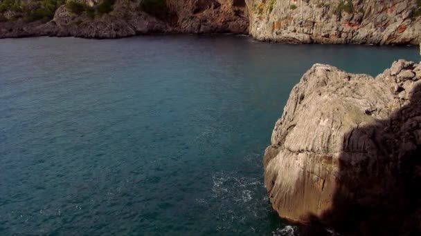 Agua del océano calma y una costa rocosa — Vídeo de stock