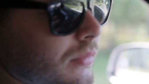 Людина в сонцезахисних окулярах за кермом автомобіля — стокове відео