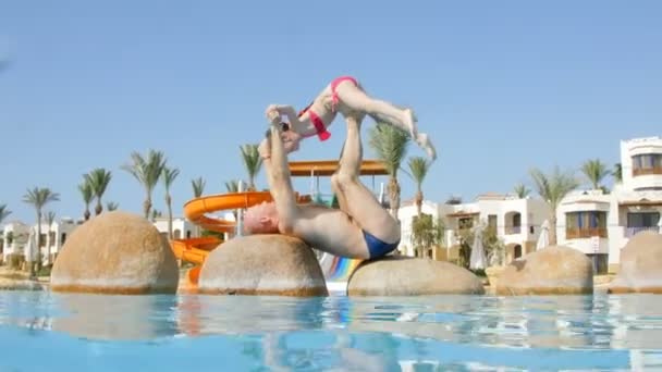 Papa spielt mit ihrer Tochter Übungen im Pool — Stockvideo