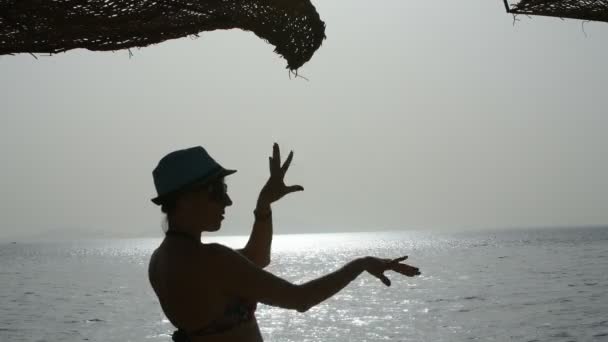 Silhueta dança menina bonita ao nascer do sol perto do mar — Vídeo de Stock