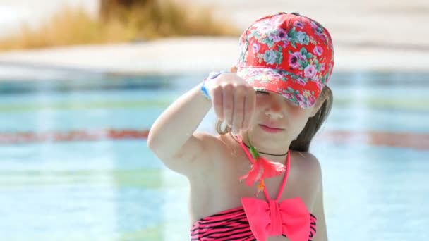 Mooi meisje speelt met een bloem in het zwembad — Stockvideo