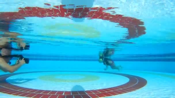 Uma menina e um fotógrafo na piscina subaquática — Vídeo de Stock