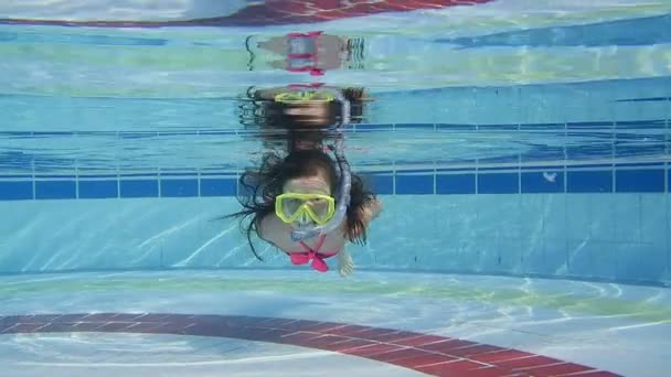 Niña nadando bajo el agua en la piscina — Vídeo de stock