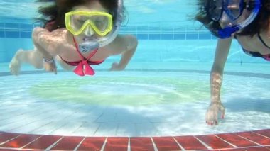 Anne ve kızı havuzda su altında yüzmek