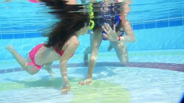 Мати і дочка плавають під водою в басейні — стокове відео