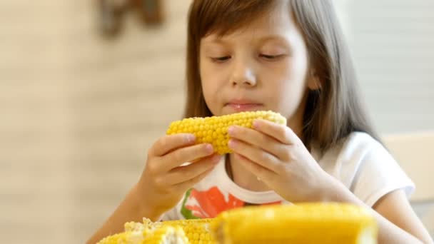 Meisje eet een gekookte maïs — Stockvideo