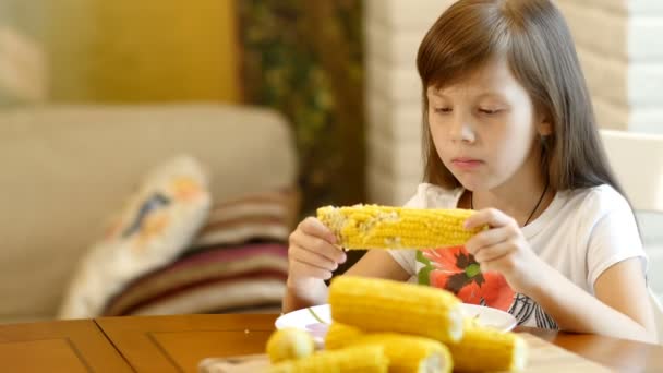 Meisje eet een gekookte maïs — Stockvideo