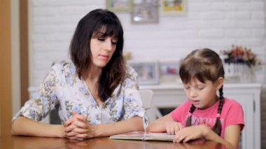 Anne ve kızı kitap okuyorlar.