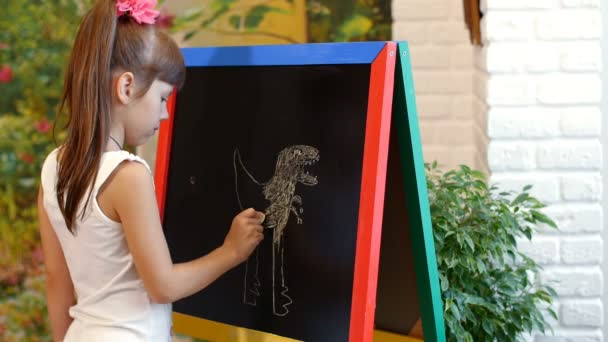 Маленькая девочка рисует на мольберте — стоковое видео