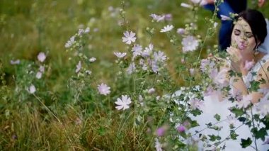 Yeni evli bir alanda - gelin ve damat yürüyüş çiçeklerle oynuyorlar
