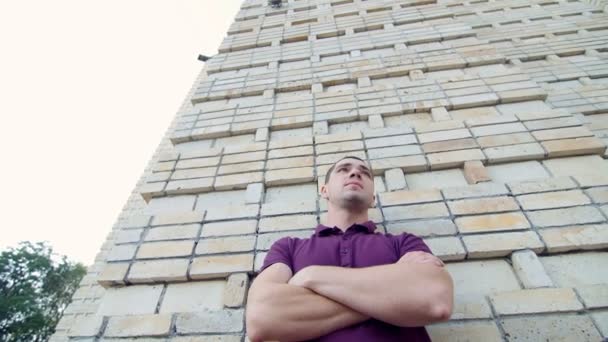 Man stands near a wall, waiting for his girlfriend - said by mobile phone — Stock Video