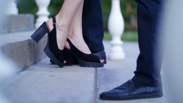 Guy comes up to the girl - feet on the stairs — Stock Video