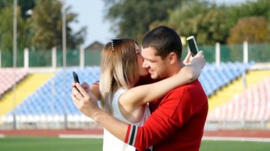 genç bir adam ve güzel kız - futbol sahasına, cep telefonunuzda bir iletiyi okumayı