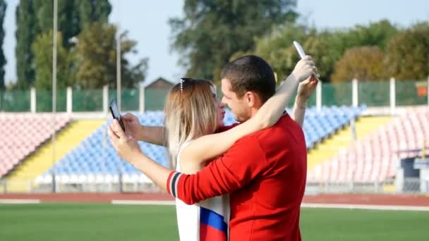 젊은 남자와 아름 다운 여자 축구 필드에 selfie를 하 고 — 비디오