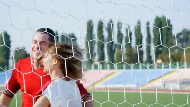 Молодой человек и красивая девушка танцуют на футбольном поле — стоковое видео