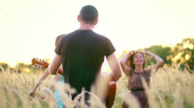 güzel kızlar ve erkekler sivri günbatımında alanında - yürüme