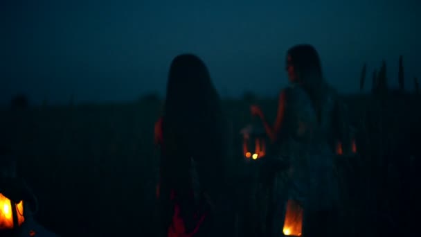 Meninas bonitas andando no campo - nas mãos segurando lanternas de vela — Vídeo de Stock