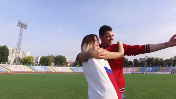 Vacker flicka och killen gör selfie på stadion — Stockvideo