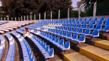 genç bir adam ve güzel kadın bir futbol stadyumu - aero bir kitap okuma