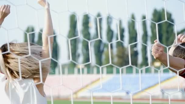 Молодий чоловік і красива дівчина танцює на футбольному полі — стокове відео