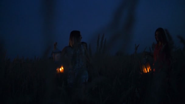 Las muchachas hermosas que caminan en el campo - en las manos que sostienen las linternas de vela — Vídeos de Stock