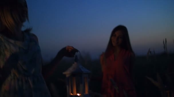 Gyönyörű lány sétál a mező - gazdaság gyertya lámpák kezében — Stock videók