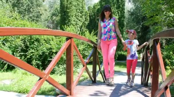 Mãe e filha vão na ponte no parque — Vídeo de Stock