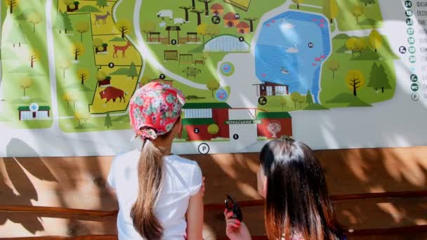 Мать и дочь изучают карту зоопарка — стоковое видео