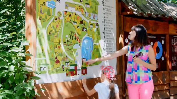 Madre e hija están estudiando el mapa del zoológico — Vídeo de stock