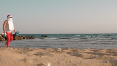 Noel Baba yaz tatili. Noel Baba eğleniyor. Güneş gözlüklü, yüzgeçli ve şnorkelli komik Noel Baba deniz sahilinde koşar. Yüzmek için acele ediyor, şnorkel..