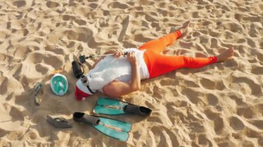 Noel Baba blogcusu. Noel Baba selfie çeker. Güneş gözlüklü komik Noel Baba, deniz kenarındaki kumlu sahilde uzanırken selfie videosu çekiyor. Noel Baba yaz tatili.