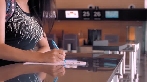 Медицинская анкета. крупным планом. Женщина заполняет документы в аэропорту. новые правила и ограничения после окончания эпидемии коронавируса. Возобновление рейсов, открытые границы — стоковое видео