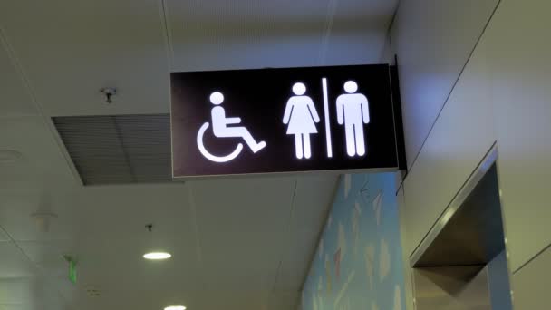 Firma. puntero. inodoro o WC. Letrero letrero de inodoro para discapacitados, inodoro para personas con discapacidad. Símbolos femeninos y masculinos en platos para baños públicos, armarios de agua. Puntero wc en el aeropuerto — Vídeo de stock