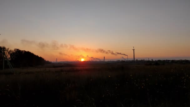 工業都市の明るいオレンジ色の夕日。暗い輪郭と赤い夕日を背景に工場の煙突のシルエット. — ストック動画