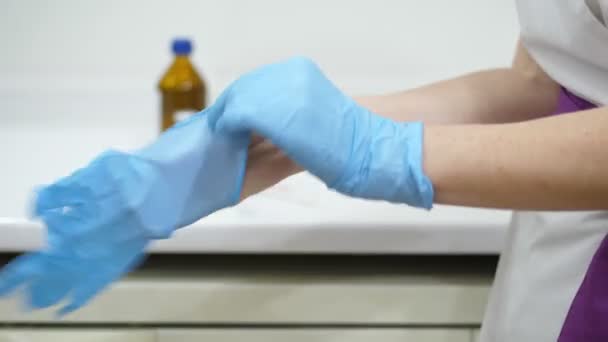 Vacunación contra el Coronavirus. primer plano, una enfermera se pone guantes médicos azules en la sala de vacunación. vacunación contra el coronavirus, COVID-19. nueva vacuna para la prevención, inmunización y tratamiento de — Vídeo de stock