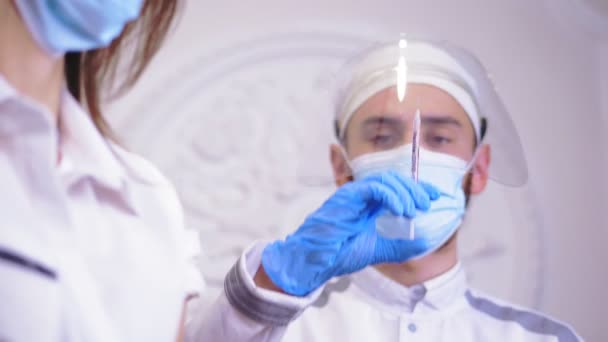 Coronavirus Vaccination. doctor, in medical mask and gloves, holding a syringe with covid-19 vaccine in his hand, for patient to be injected, vaccinated. global, mass vaccination for prevention — Vídeo de stock