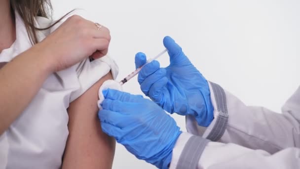 Coronavirus vaccination. close-up. nurse, in blue medical gloves, injects vaccine into patients shoulder. covid-19 vaccination. new vaccine for prevention, immunization and treatment of coronavirus — Vídeo de stock