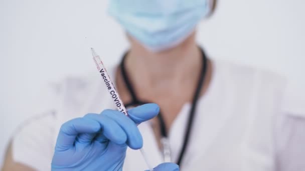 Coronavirus Vaccination. close-up, female doctor, in medical mask and gloves, holding a syringe with covid-19 vaccine in her hand. new vaccine for prevention, immunization and treatment of coronavirus — Vídeo de stock