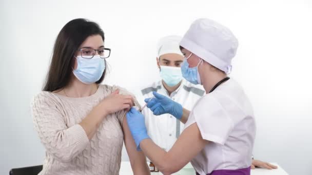 Coronavirus vaccination. nurse or doctor, in protective mask and medical gloves, injects vaccine into patients shoulder in clinic. new vaccine for prevention, immunization and treatment of — Vídeo de stock