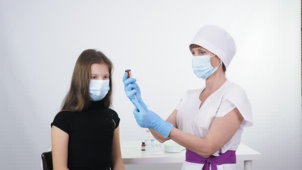 Coronavirus vaccination of children. nurse or doctor, in protective mask and medical gloves, draws liquid vaccine from small glass bottle into syringe for covid-19 vaccination. global, mass — Αρχείο Βίντεο