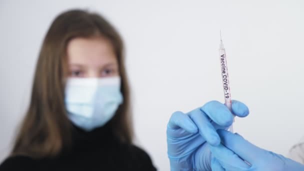 Coronavirus-Impfung. Nahaufnahme, die Hände der Ärzte, in medizinischen Handschuhen, in der Hand eine Spritze mit Covid-19-Impfstoff für den zu injizierenden Patienten, geimpft. Globale Massenimpfung zur Vorbeugung — Stockvideo
