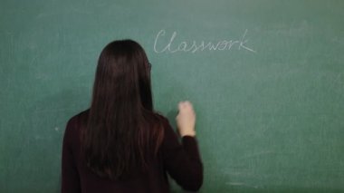 Çevrimiçi eğitim. Öğretmen online matematik dersi sırasında materyalleri açıklıyor. Kurallar yazıyor. Tahtaya tebeşirle yazılmış formüller. Okulda. Uzaktan eğitim. Sınıftan canlı video yayını.