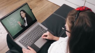 Öğretmenle çevrimiçi video görüşmesi. Uzaktan öğrenme. Liseli kız online ders alıyor, video görüşmesi yapıyor, öğretmenle konuşuyor, dizüstü bilgisayar kullanıyor. Evde online ders çalışıyorum..