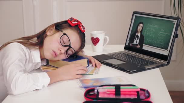 Educación a distancia, educación en línea. cansada, colegiala agotada se quedó dormida en el escritorio frente a la pantalla del ordenador portátil mientras veía la lección de video tutorial. Educación a distancia, enseñanza en línea, e-learning. — Vídeos de Stock