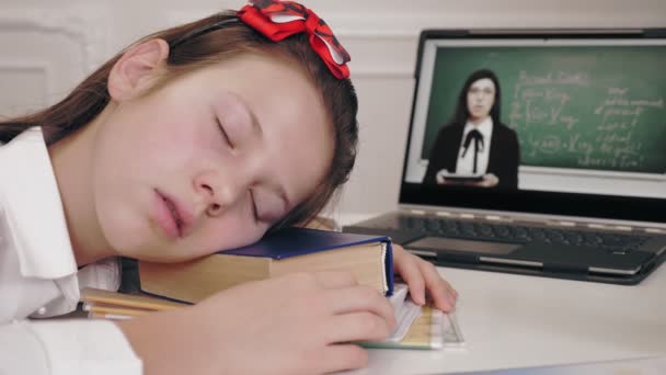 Distance learning, online schooling. tired, exhausted schoolgirl fell asleep on desk in front of laptop screen while watching tutorial video lesson. Distant education, online schooling, e-learning. — Stock Video