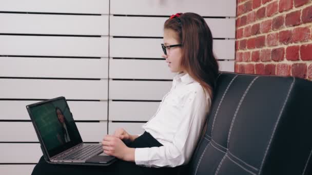Online videohívás a tanárral. távoktatás. Az iskoláslány online leckét tart, videóhívást, beszélgetést a tanárral, laptopot használ. online tanulás otthon. — Stock videók