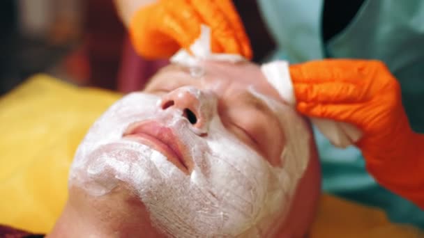 化粧品学男性はクリーニングに直面しています。男性用化粧品の手順。接近中だ。男はソファに横になって顔の洗浄手順を取得している美容クリニックで。スキンケア、皮膚科治療. — ストック動画