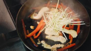 Yemek pişirmek. Yakın plan. Sebzeli et parçaları tavada kızartılır. Üst Manzara. Aşçılık