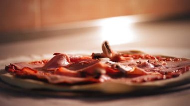 Aşçılık. Pizza yapmak. - Yakın çekim. Şef dilimlenmiş mantarları pizza hamuruna koyar. Geleneksel İtalyan pizzası pişirmek. İtalyan Yemekleri.