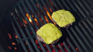 Aşçılık. Hamburger pişirmek. Yakın plan. Izgara taze et burger köfteleri ve erimiş sarı peynir. Kızarmış et madalyonları ızgarada kızartılıyor. fast food, abur cubur